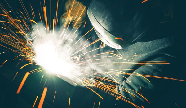 Professional Welder is Welding Two Metal Parts Together. Sparks Flying All Around. Metal Industry Theme.